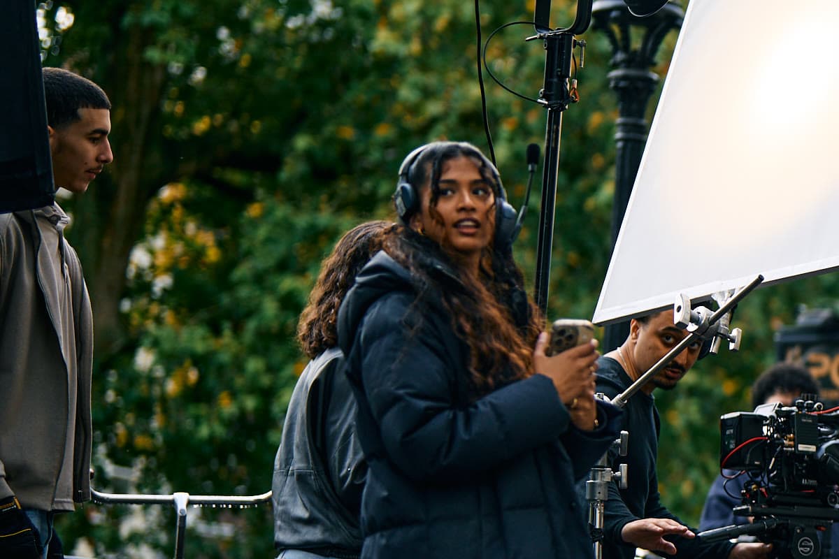 Aneesa met koptelefoon naast de monitor op een draaidag in Amsterdam