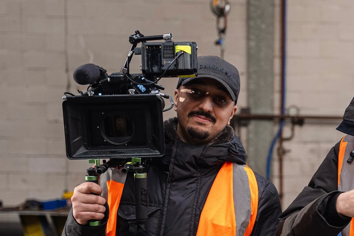 Sofyan Belghali met de camera op zijn schouder in een staalhal