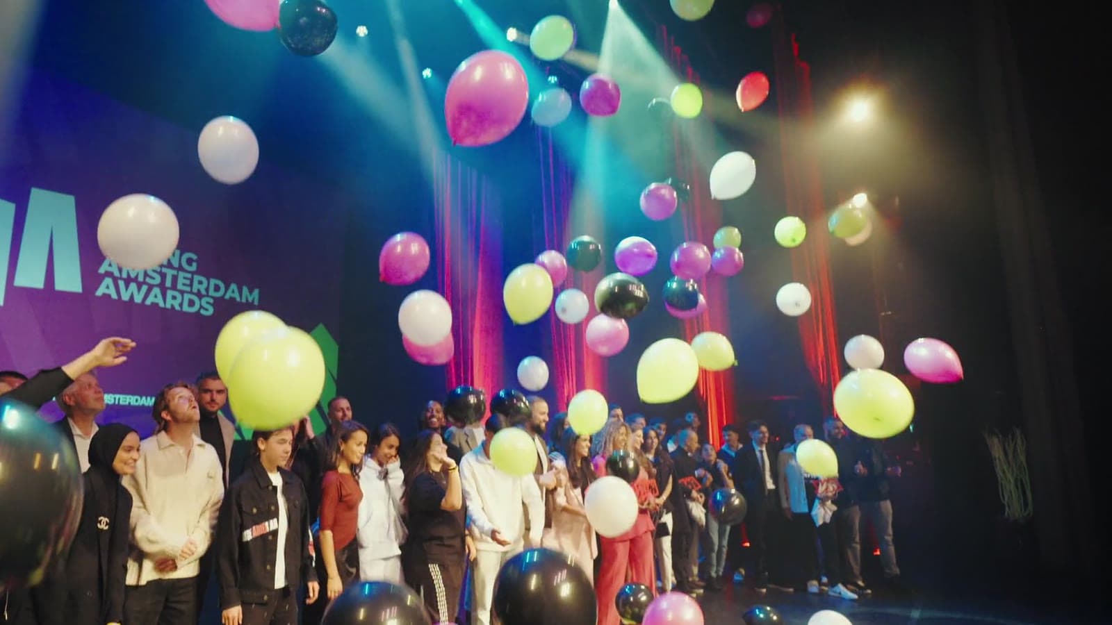 Ballonnen vallen op het podium boven de winnaars, still uit de aftermovie van de YoungAmsterdam Awards