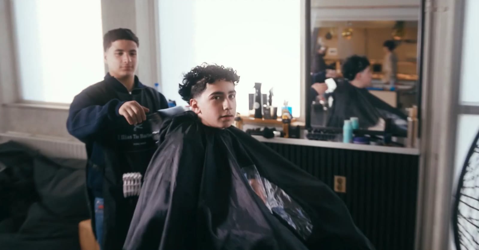 Een kapper knipt een jongen tijdens de opening, still uit de commercial over Plein 34 in Nieuwegein